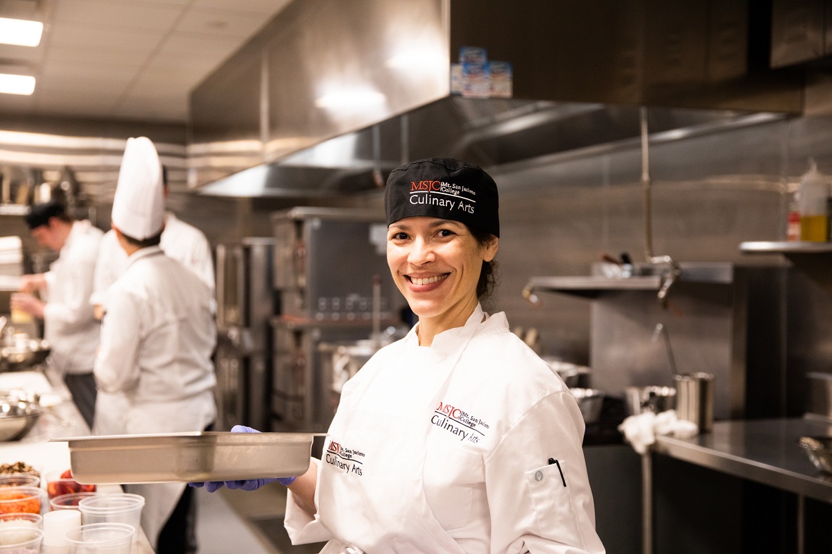 culinary student smiling in a professional kitchen