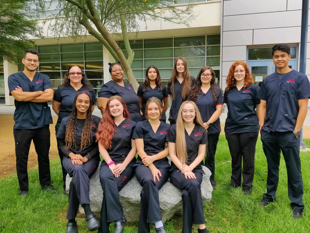 students in black medical uniforms smiling as a group. class of 2025 for the diagnostic medical sonography program at MSJC